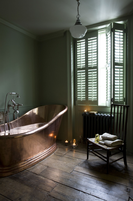 Green bathroom with brase bathroom and green shutters